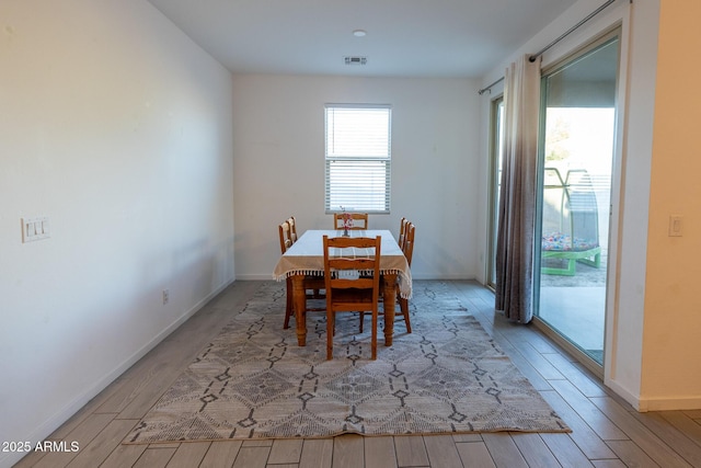 dining room with wood finished floors, visible vents, and baseboards