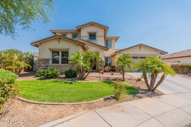 mediterranean / spanish-style house featuring a front lawn and a garage