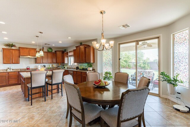 dining space with sink, an inviting chandelier, and light tile patterned floors