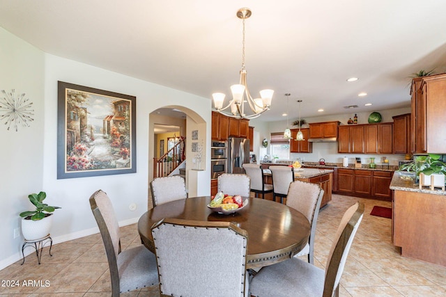 tiled dining room featuring an inviting chandelier