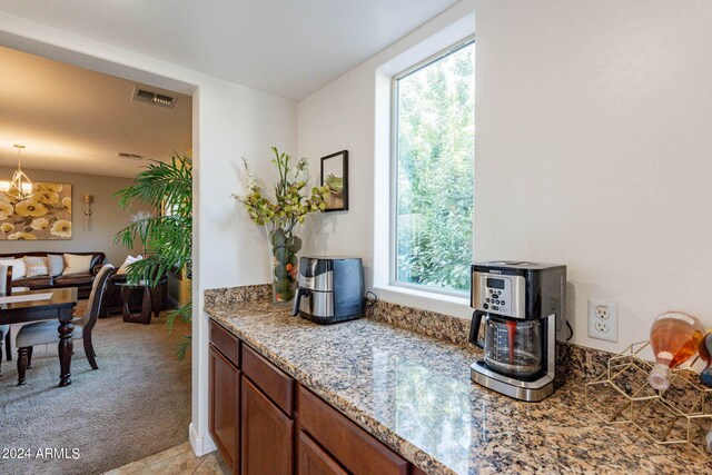 kitchen with sink, stainless steel gas cooktop, light tile patterned floors, and light stone counters