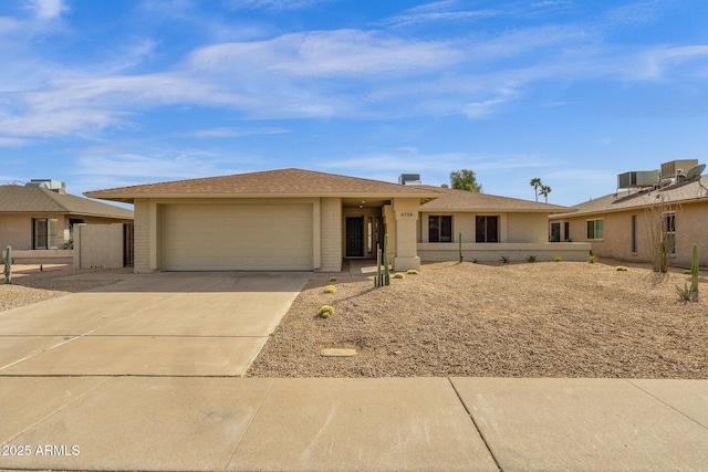 ranch-style home featuring a garage and driveway