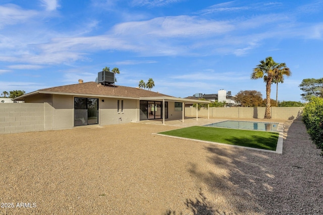 rear view of property featuring a yard, a fenced backyard, a patio area, and cooling unit