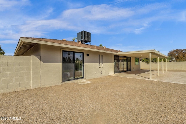 rear view of house featuring central air condition unit, a patio area, fence, and brick siding