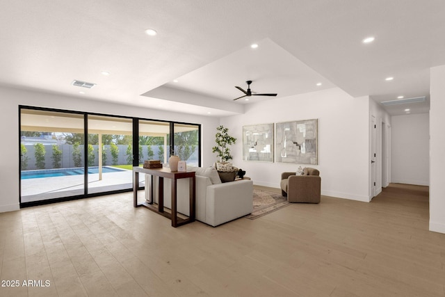 living area with light wood-style flooring, visible vents, and recessed lighting