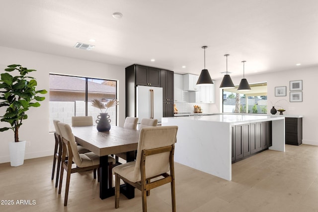 dining space with recessed lighting, visible vents, plenty of natural light, and light wood finished floors