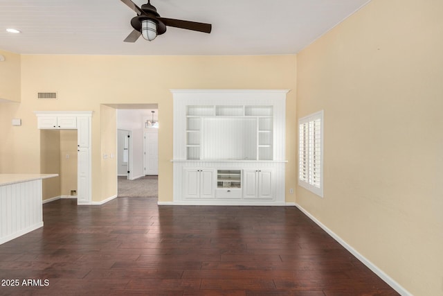 spare room featuring a ceiling fan, dark wood-type flooring, and baseboards
