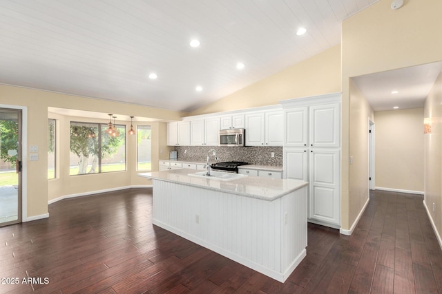 kitchen featuring stainless steel microwave, dark wood-style floors, a sink, white cabinets, and lofted ceiling
