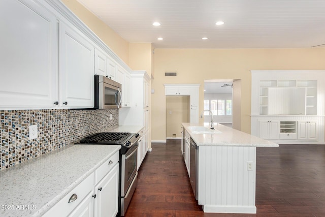 kitchen featuring appliances with stainless steel finishes, a sink, recessed lighting, dark wood-style flooring, and tasteful backsplash