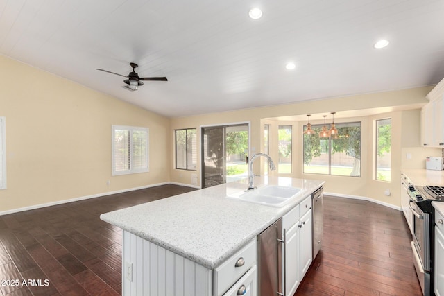 kitchen featuring a sink, appliances with stainless steel finishes, baseboards, lofted ceiling, and dark wood-style floors