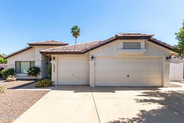 view of front facade featuring driveway, stucco siding, a garage, and a tile roof