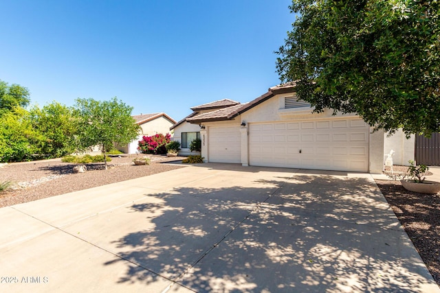 view of front of home featuring stucco siding, concrete driveway, an attached garage, and a tiled roof