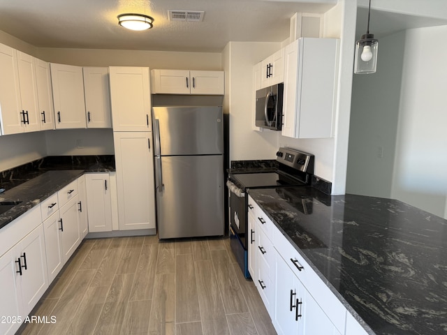 kitchen with white cabinetry, visible vents, light wood-type flooring, and stainless steel appliances