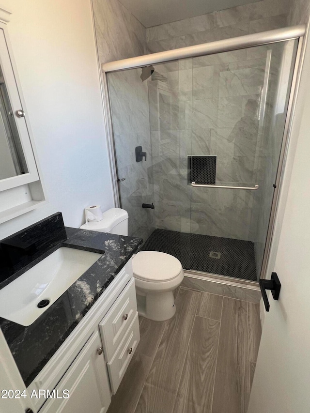 bathroom featuring walk in shower, vanity, and toilet