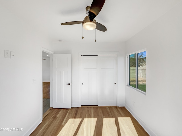 unfurnished bedroom with light wood-type flooring, a closet, and ceiling fan