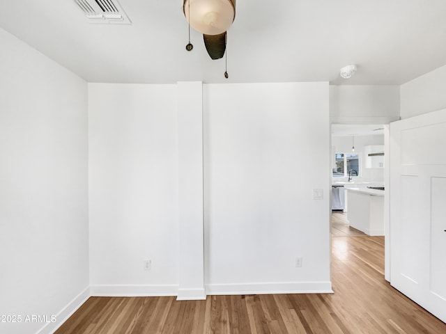 unfurnished room with ceiling fan and light wood-type flooring