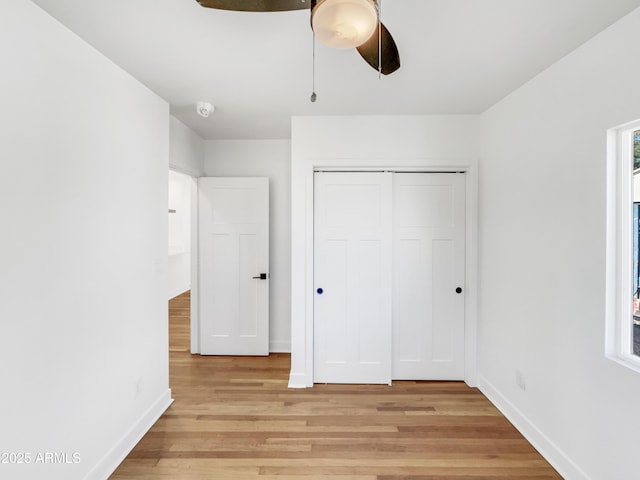 unfurnished bedroom with ceiling fan, light wood-type flooring, and a closet