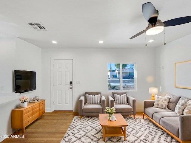 living room with light hardwood / wood-style flooring and ceiling fan