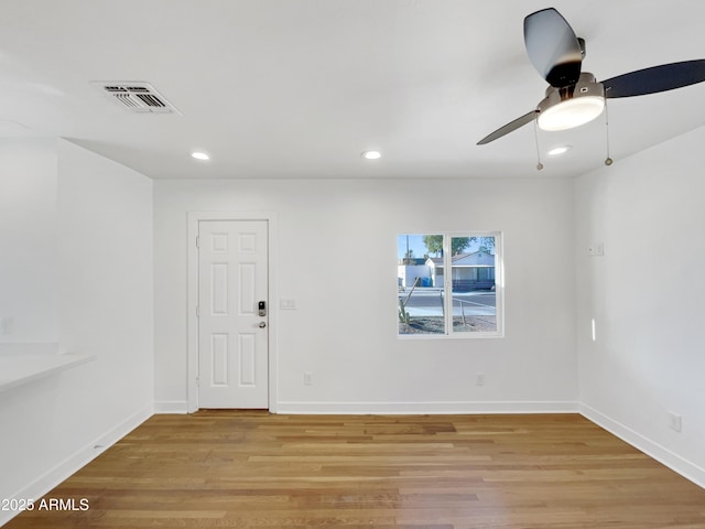 spare room with ceiling fan and light wood-type flooring