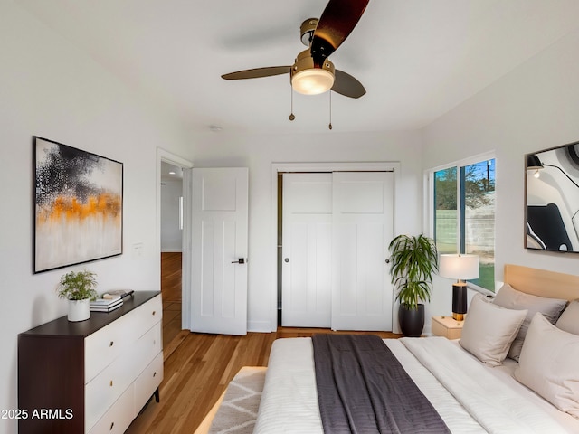 bedroom featuring a closet, light hardwood / wood-style flooring, and ceiling fan