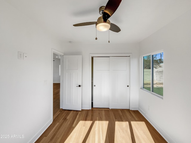 unfurnished bedroom with ceiling fan, a closet, and light hardwood / wood-style floors