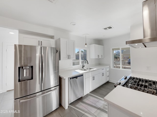 kitchen with appliances with stainless steel finishes, island range hood, sink, light tile patterned floors, and white cabinets