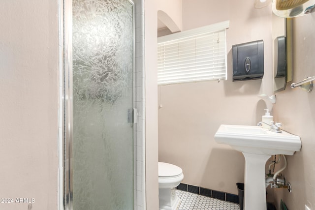 bathroom with a shower with shower door and toilet