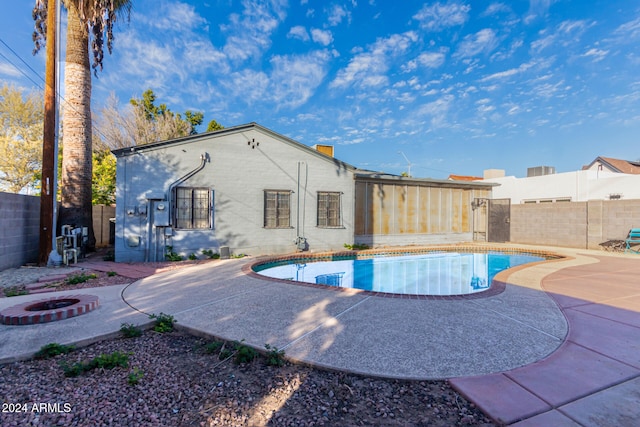 view of swimming pool with an outdoor fire pit and a patio area