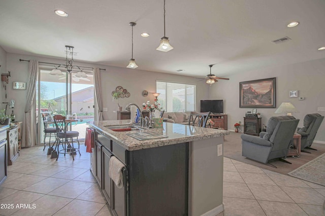 kitchen with light tile patterned floors, pendant lighting, a sink, and open floor plan