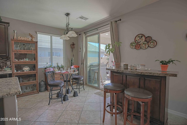 dining room with light tile patterned floors, baseboards, and visible vents