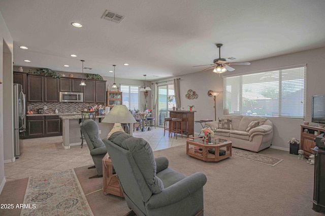 living area featuring light tile patterned floors, baseboards, visible vents, and recessed lighting