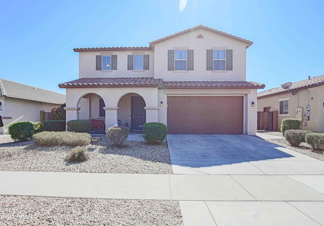 mediterranean / spanish-style house featuring driveway, a porch, an attached garage, and a tiled roof