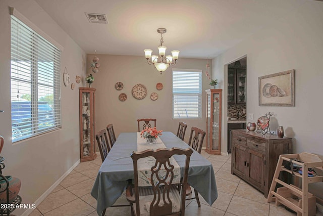 dining area with visible vents, a notable chandelier, baseboards, and light tile patterned floors