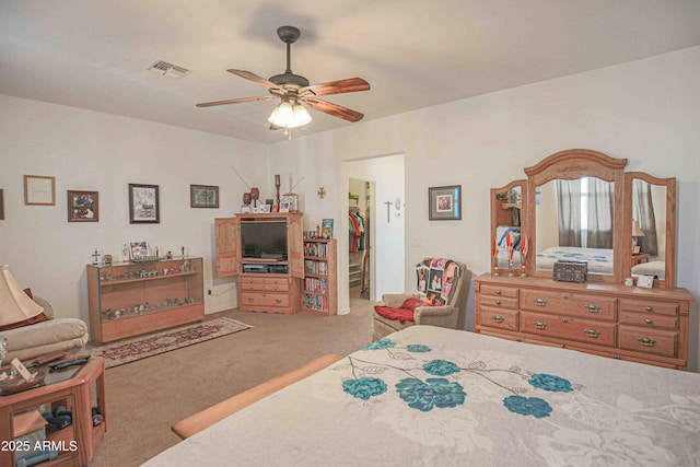 bedroom featuring ceiling fan, carpet floors, visible vents, a closet, and a walk in closet