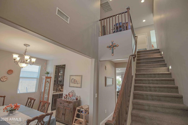 staircase with recessed lighting, visible vents, and an inviting chandelier