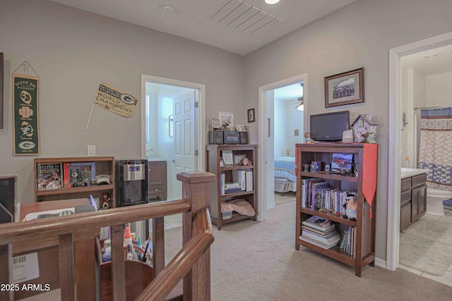 bedroom with light carpet and connected bathroom