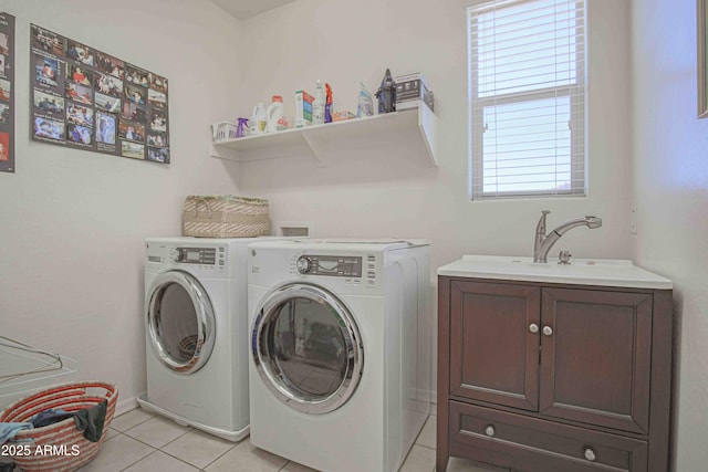 washroom with cabinet space, a sink, washer and clothes dryer, and light tile patterned flooring