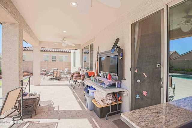 view of patio featuring ceiling fan and fence