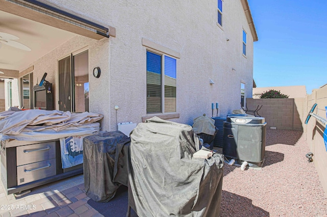 exterior space featuring a fenced backyard, ceiling fan, and stucco siding