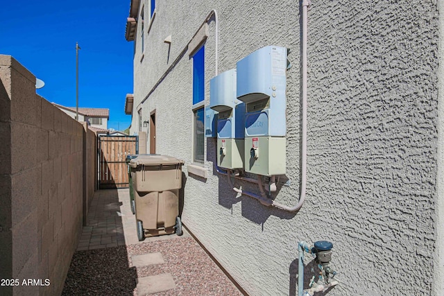 view of side of home with fence and stucco siding