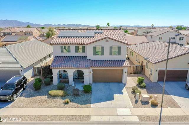 mediterranean / spanish house with covered porch, concrete driveway, a tile roof, and a residential view