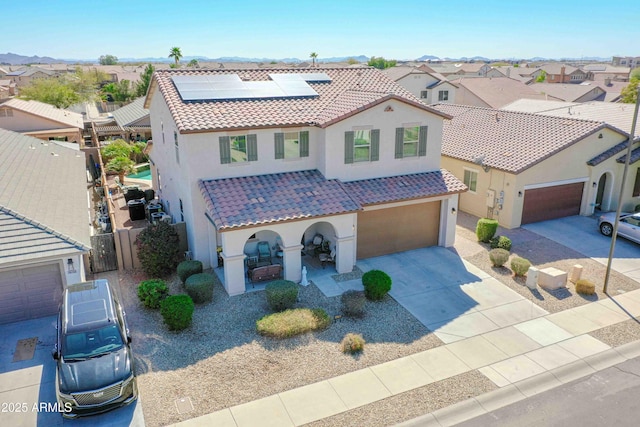 mediterranean / spanish home featuring a tile roof, stucco siding, fence, a residential view, and driveway