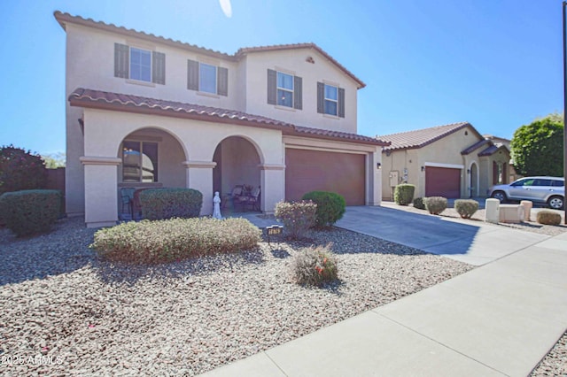 mediterranean / spanish-style house featuring driveway, an attached garage, a tiled roof, and stucco siding