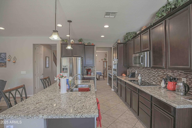 kitchen with dark brown cabinets, appliances with stainless steel finishes, a sink, and visible vents