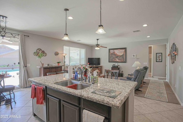 kitchen featuring pendant lighting, visible vents, open floor plan, light tile patterned flooring, and a sink