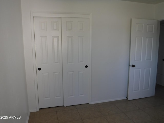 unfurnished bedroom featuring a closet and tile patterned flooring