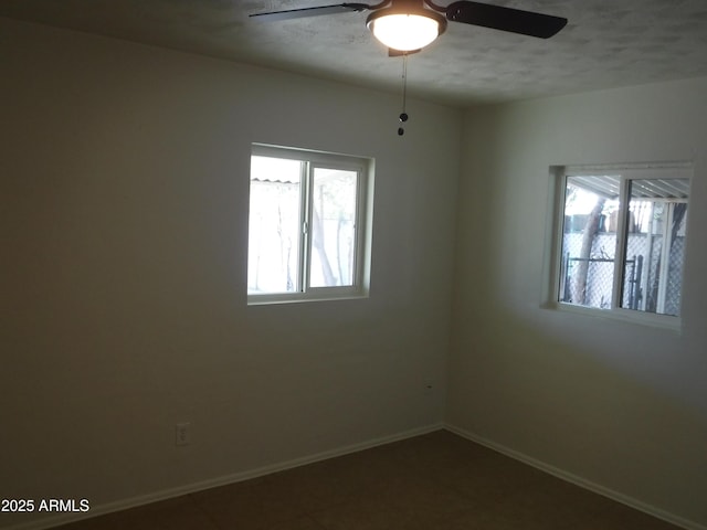 spare room with ceiling fan and a wealth of natural light