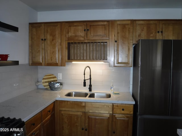 kitchen with decorative backsplash, sink, and black fridge