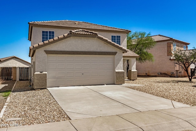 traditional-style home with driveway, a tiled roof, an attached garage, fence, and stucco siding