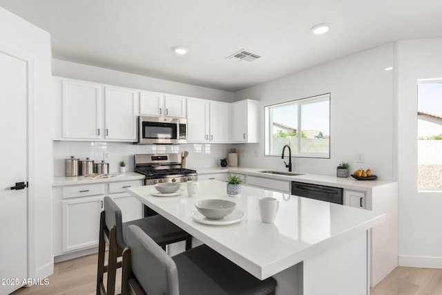 kitchen featuring tasteful backsplash, a healthy amount of sunlight, stainless steel appliances, and a sink